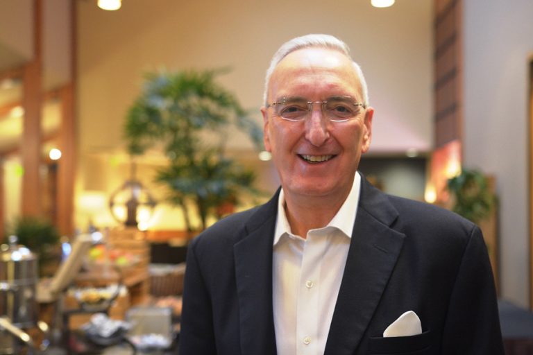 Boaz Power smiling during a leadership event, wearing a dark blazer and white shirt
